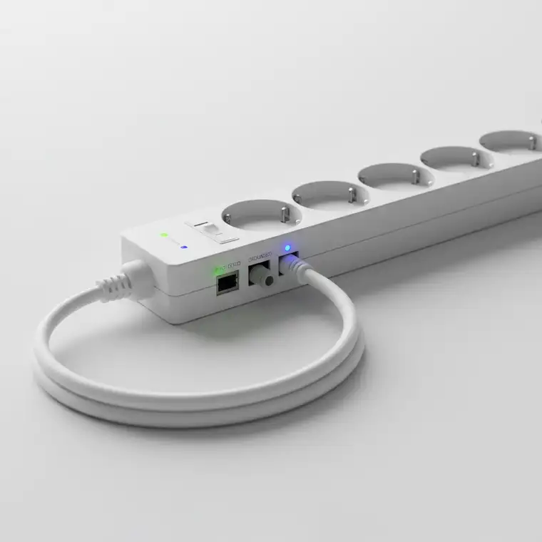 Listwa antyprzepięciowa pod biurkiem zabezpieczająca komputer, monitor i telewizor w jednym pokoju, pokazująca praktyczne użycie ochrony przepięciowej